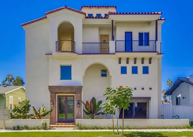 Three-story Spanish-style home with balconies and a tiled roof in coastal San Diego